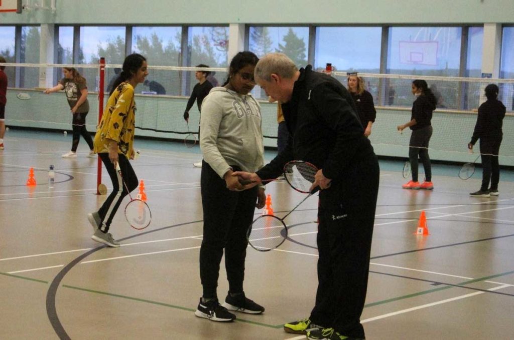 Players learn the correct forehand grip for the high serve